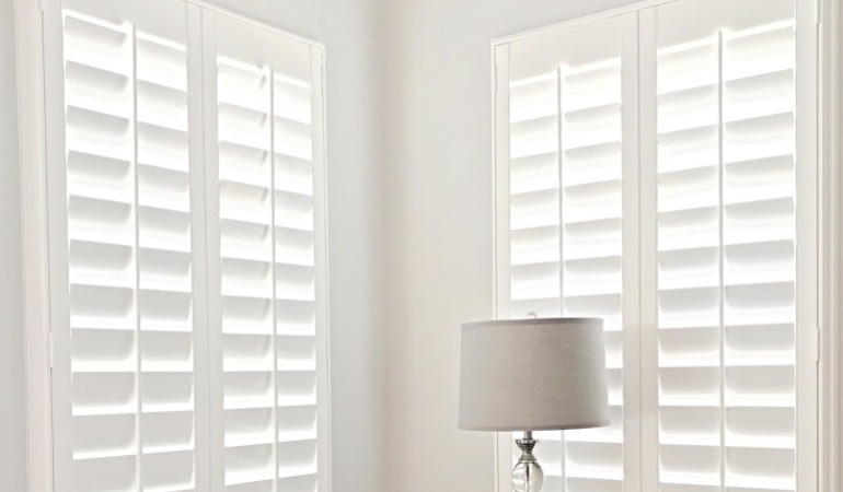Plantation shutters come in a wide array of neutral whites and wood stains. Plantation shutters in a corner window.