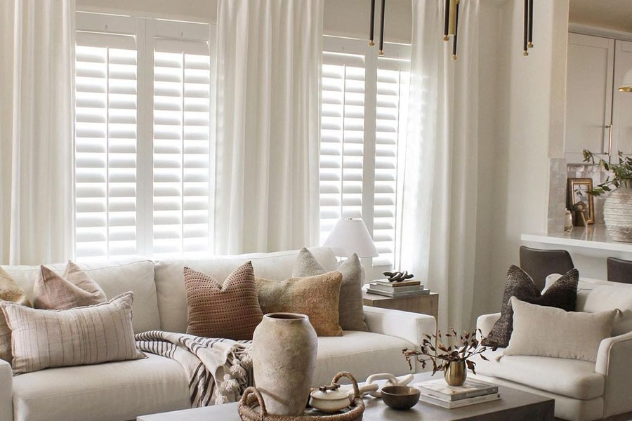 Brown and off-white living room with white polywood shutters.