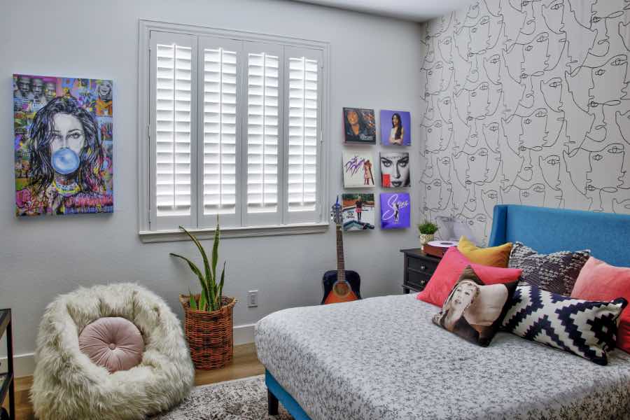 Whether your tastes run modern or traditional, there's a plantation shutter for your home decor. White Polywood shutters on a window in a trendy teen bedroom.