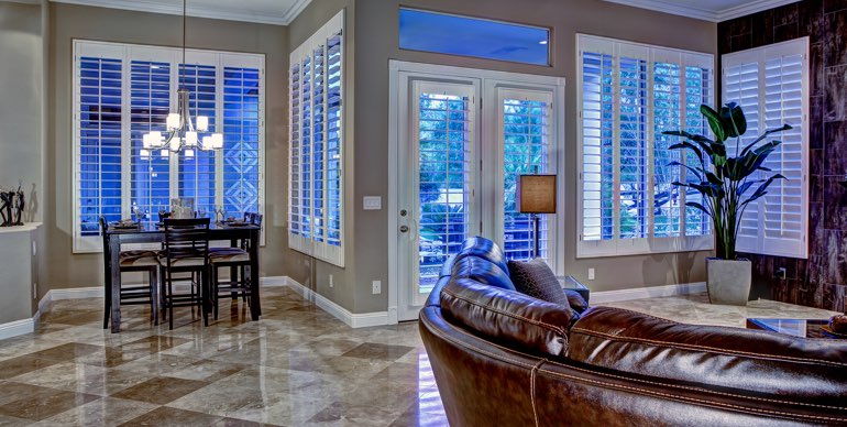 Photo Courtesy of Room Resolutions Charlotte great room with plantation shutters and tile floor.