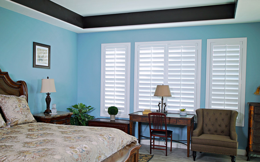 Polywood shutters provide insulation for the perfect temperature all year long in Charlotte. Polywood shutters in a bedroom.