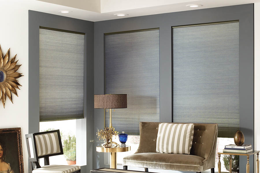 Add style and comfort to your home with cellular shades in Charlotte. Gray cellular shades in a corner of a stylish living room.