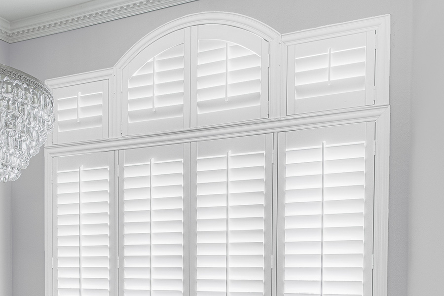 Customize your Palladian windows with white Polywood shutters in Charlotte. White Polywood Palladian windows in a dining room.